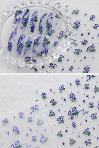 Détail macro de stickers ongles 5D fleurs de liseron avec texture 3D et strass fins