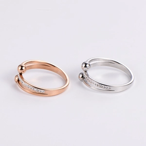 Close-up of adjustable rose gold and silver rings with zircon inlay on white background