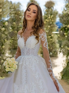 Detail of luxury bridal gown with vine lace embroidery and sheer long sleeves
