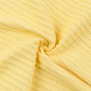 Close-up detail of yellow striped textured fabric with a high-quality knitted embossed feel