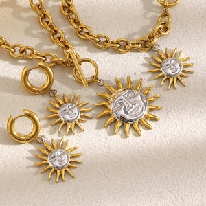 Detail view of 18K gold plated O-chain necklace and earrings with sun face pendants