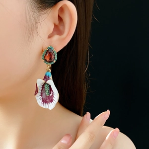 Detailed view of vintage enamel flower earrings with red gemstone and crystal on model