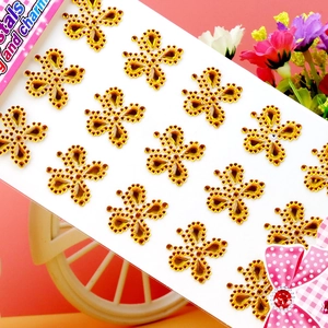 Detailed view of golden butterfly acrylic crystal stickers in a decorative pink setting