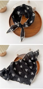 Detail of black cotton linen triangle scarf with white floral embroidery and lace trim