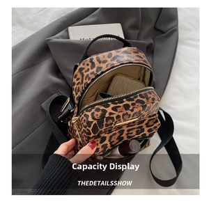 Detail view of mini leopard print backpack showing interior storage for phone and makeup