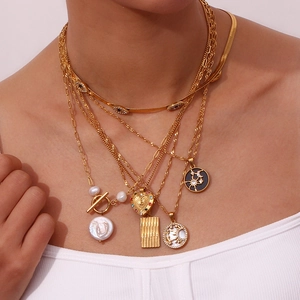 Detail of layered 18K gold plated stainless steel necklaces with heart and moon pendants