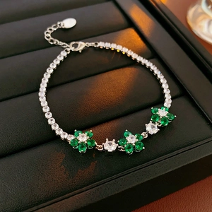 Macro view of green flower bracelet with sparkling cubic zirconia on black leather