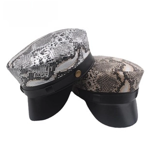 Detail view of corduroy navy caps with faux snakeskin texture and brass side buttons