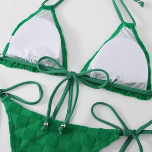Detail of green bikini with checkerboard texture and metallic bead ties on side