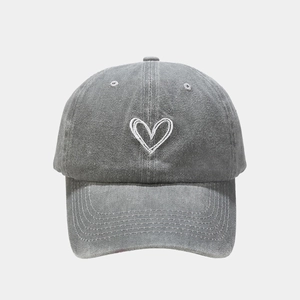 Nahaufnahme einer gewaschenen grauen Baseballkappe mit weißem Herz-Stickerei-Design