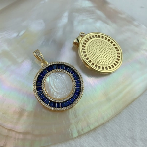 Detailed macro view of gold-plated Virgin Mary shell pendants with blue gemstones