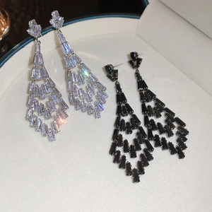 Close-up of tiered tassel earrings with sparkling cubic zirconia in silver and black finish