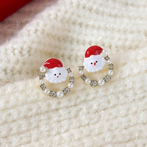 Close-up of asymmetrical Santa Claus earrings with red enamel, pearls and crystals
