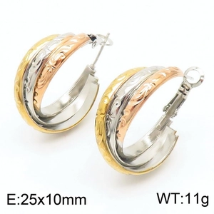 Close-up of tricolor interlocking hoop earrings with engraved vine floral patterns
