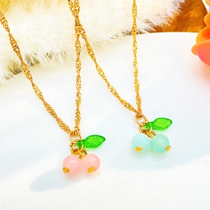 Collane con ciondolo a ciliegia con perle rosa e blu su vassoio bianco elegante