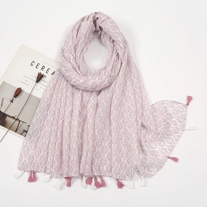 Detailed view of white scarf with pink leaf patterns and soft fringe trim on white background