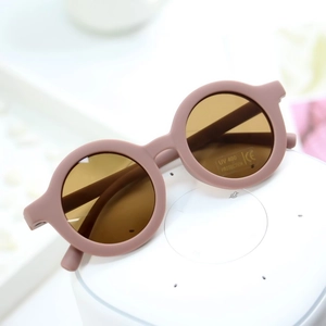 Detail of round matte pink kids sunglasses with UV400 and CE certification labels