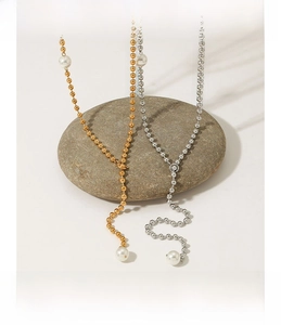 Detailed view of Y-shaped pearl necklaces in gold and silver finish over stones