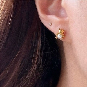 Chic 925 silver golden bear earrings with white pearl accent shown in a side-view model shot