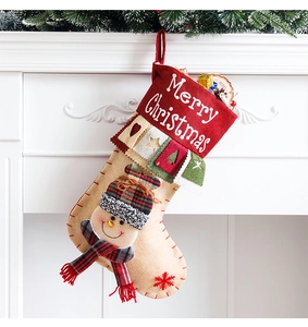 Close-up of red Christmas stocking with 3D snowman hanging on white fireplace