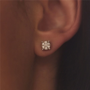 Macro shot of silver geometric square stud earrings with brilliant diamonds on ear