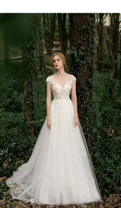 Detailed view of exquisite lace floral embroidery and sheer bodice on white wedding gown