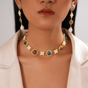 Retro gold jewelry set with colorful gemstones and baroque pearls on model
