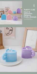 Close-up of burning macaron heart candles and geometric decorative soy wax candle set