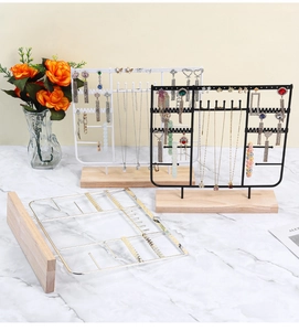 Three metal jewelry display stands with wooden bases in black, white, and golden finish