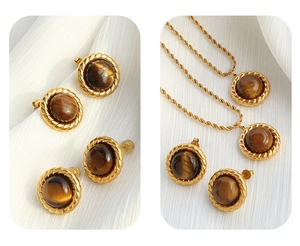 Detailed view of tiger eye jewelry set featuring gold twisted chain necklace and earrings