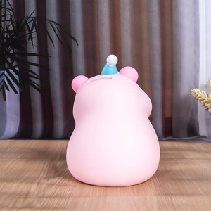 Détail de la tirelire capybara rose avec fente pour pièces et décoration de petit chapeau