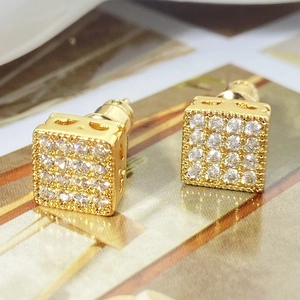 Macro detail of gold plated cube stud earrings featuring micro-pave clear cubic zirconia stones
