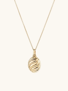 Macro shot of 18K gold plated oval locket pendant with elegant spiral wave texture