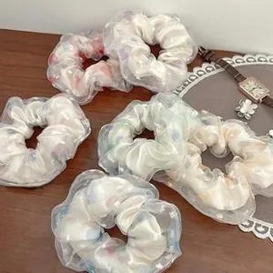 Detail of sheer organza hair scrunchies with colorful polka dots on a wooden table