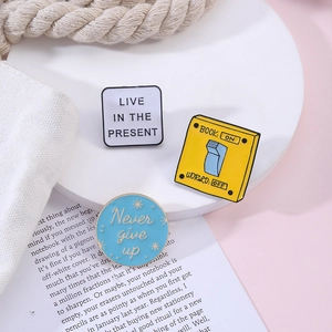 Three creative enamel pins featuring motivational quotes on a stylish pink aesthetic background