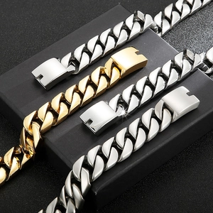 Classic Cuban link bracelets in gold and silver steel on black geometric blocks