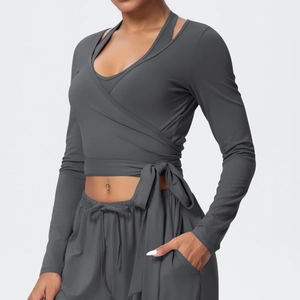 Detail of dark grey yoga set featuring wrap-style tie-up top and drawstring joggers