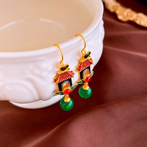 Macro view of Chinese palace style heart tassel earrings with red and blue enamel detail
