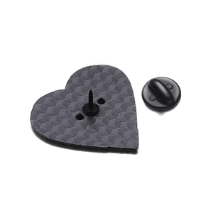 Macro view of heart-shaped metal badge back featuring honeycomb texture and rubber clasp