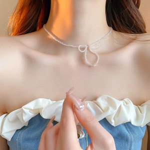 Close-up of translucent crystal bead choker with bow pendant worn by a model