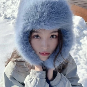 Dettaglio del cappello invernale blu in ecopelliccia su uno sfondo esterno innevato