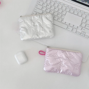 Detailed view of quilted bow pouches in pearl white and pink with metallic zipper and lanyard