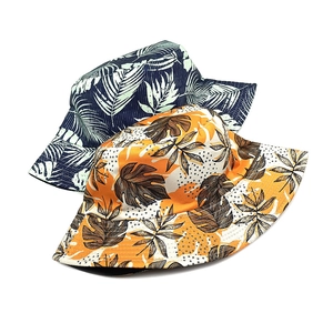 Double-sided sun hat with tropical leaf prints in navy blue and yellow canvas