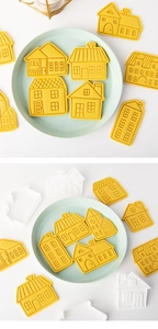 Détail des emporte-pièces en forme de maison et des biscuits jaunes finis sur une assiette