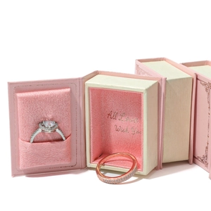 Pink book-shaped velvet jewelry box with magnetic closure and two rings inside