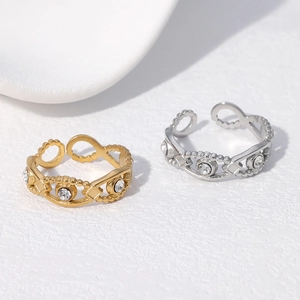 Minimalist gold and silver open rings with clear zircon stone on white textured surface