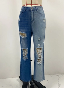 Dettaglio dei jeans strappati con design patchwork blu e finiture distressed