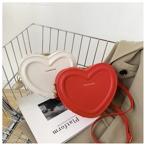 Dettaglio di borse a forma di cuore in pelle PU rossa e bianca in un carrello di metallo