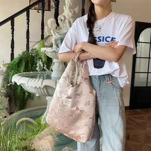 Close-up of pink jacquard tote bag featuring butterfly prints and Bozakka label details