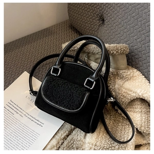 Detail of black teddy plush handbag featuring faux leather trim and silver metal hardware